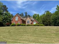 Beautiful brick and stone home with well-manicured lawn and lush landscaping at 1209 Persimmon Way, Mcdonough, GA 30252