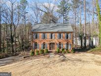 Charming two-story brick home featuring blue shutters and lush landscaping at 505 Summer Ter, Woodstock, GA 30189