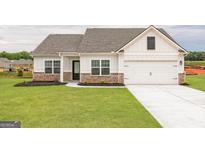 Charming single-Gathering home with green lawn, brick accents, and attached two car garage at 1029 Claas Way, Locust Grove, GA 30248