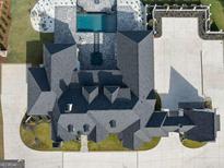 An aerial view of a luxury home featuring a pool, manicured lawns, and a circular driveway at 4100 Oak Hill Rd, Douglasville, GA 30135