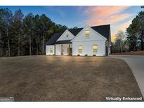 Beautiful white farmhouse-style home with a dark roof and a spacious front yard at 1017 Riverstone Dr, Social Circle, GA 30025