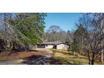 Single-story home with attached garage and mature trees in a serene, wooded setting at 40 Circle Dr, Hampton, GA 30228