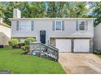 Charming home featuring a two-car garage, gray siding, stone accents, and well-maintained landscaping at 2232 Ramblewood Ne Cir, Decatur, GA 30035
