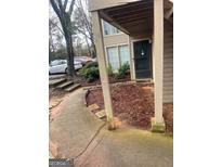 Exterior view of the home's front door with storm door, and the adjacent landscape at 1362 Brockett Pl, Clarkston, GA 30021