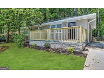 Charming single-story home featuring a brick facade, a new wooden porch, and a well-manicured front lawn at 4352 Glenwood Pkwy, Decatur, GA 30032