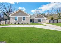 Beautifully landscaped single-story home with brick facade and long driveway at 5319 Orly Ter, South Fulton, GA 30349