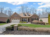 Charming brick home featuring a manicured lawn and a two-car garage at 4930 Cecilia Sq, Cumming, GA 30040