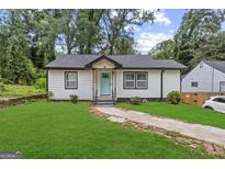 Charming single-story home with freshly cut lawn and walkway leading to a delightful turquoise front door at 1077 Peeples Sw St, Atlanta, GA 30310
