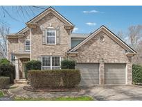 Charming brick home featuring a two-car garage and well-maintained landscaping at 6448 Mobilis Ct, Sugar Hill, GA 30518