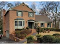 Charming brick two-story home with a bay window, dark green shutters and landscaped front yard at 301 Millbrook Farm Ct, Marietta, GA 30068