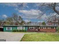 Charming single-story home with a lush green lawn and a cozy front porch at 10174 Twin Oaks Sw Dr, Covington, GA 30014