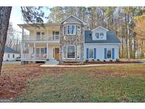 Inviting two-story home featuring a stone accent wall, double decks, and a well-maintained front yard at 215 Farr Lake Dr, Tyrone, GA 30290