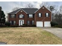 Charming two-story brick home with a two-car garage and traditional architectural details at 11 Carriage Lake Dr, Stockbridge, GA 30281