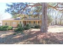 Traditional two-story home featuring a charming front porch, mature landscaping, and a well-maintained yard at 401 Waterwood Bnd, Peachtree City, GA 30269