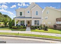 Charming two-story home with a covered front porch and well-manicured lawn in a suburban neighborhood at 1977 Boyd Trace Nw Ln, Atlanta, GA 30318