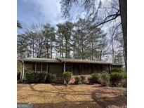 Ranch home with a covered front porch surrounded by mature trees at 5970 Avenue Of Redwoods, South Fulton, GA 30349
