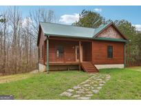 Charming log cabin featuring a quaint front porch and a stone pathway leading to the entrance at 1266 Martin Mill Rd, Moreland, GA 30259
