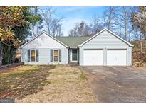 Charming single-story home with a two-car garage, a green roof, and a well-maintained lawn at 121 Colemans Bluff Dr, Woodstock, GA 30188