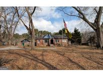 Charming brick home featuring a unique gable roof and an American flag in the front yard at 3540 Stapp Dr, Tucker, GA 30084