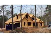 Exterior view of a partially completed home showing wood framing and windows surrounded by wooded terrain at 958 Temple Draketown Rd, Temple, GA 30179