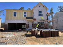 New construction home showing brick and siding, with workers present at 166 Silverton Dr, Dacula, GA 30019