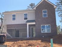 Two story home featuring a 2 car garage, and a combination of brick and vertical siding at 166 Silverton Dr, Dacula, GA 30019
