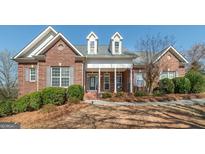 Charming brick home featuring a covered front porch and well-maintained landscaping at 408 Tomahawk Trl, Mcdonough, GA 30252