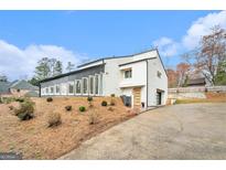 Striking modern home featuring a unique architectural design, multi-pane windows, and a driveway to the attached garage at 3365 Turtle Lake Se Dr, Marietta, GA 30067