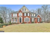 Stunning brick home with a meticulously maintained lawn and mature trees surrounding the property at 1133 Astoria Ln, Peachtree City, GA 30269