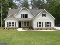Charming two-story home with white siding, dark shutters, and manicured front lawn at 240 Jay Trl, Fayetteville, GA 30215