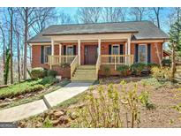 Charming brick home featuring a covered porch with wood railing and a well-manicured front yard at 150 Gill Ln, Stockbridge, GA 30281