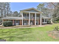 Stately two-story home with a large front yard, prominent columns, and an American flag at 401 Pinegate Rd, Peachtree City, GA 30269