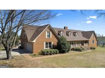 Beautiful brick home featuring an attached garage, well-manicured lawn, and lovely landscaping at 2940 E Lake Rd, Mcdonough, GA 30252