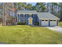 Charming two-story home featuring a yellow front door and an attached two-car garage at 117 Everhill, Peachtree City, GA 30269