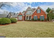 Charming two-story brick home with manicured lawn, classic architectural details, and complementary shutters at 2510 Shoreline Pkwy, Villa Rica, GA 30180