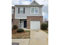 Charming townhome featuring a brick and siding exterior with an attached single car garage at 1463 River Stone Trce, Conyers, GA 30012