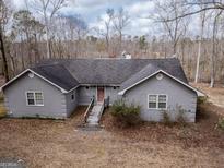 Charming single-story home with gray facade and a welcoming wooden bridge leading to the front door at 650 Malcom Rd, Covington, GA 30014