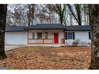 Charming single-story home featuring a bright red door, white siding and new front porch at 1620 Summit Rdg, Auburn, GA 30011