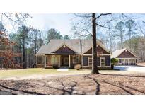Charming home boasts a stone and cedar exterior, complemented by a matching detached garage at 430 Gregory Rd, Covington, GA 30014