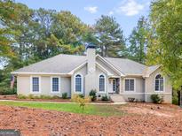 Charming single-story home with a neutral exterior, chimney, multiple windows, and a well-manicured lawn at 1300 Lakehaven Pkwy, Mcdonough, GA 30253