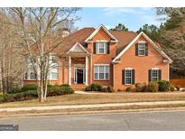 Charming brick home featuring a landscaped front yard, black shutters, and a classic architectural design at 510 Virginia Highlands, Fayetteville, GA 30215