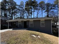 Charming brick home featuring a well-maintained front yard and a welcoming entrance at 452 Fedora Nw Way, Atlanta, GA 30331