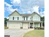 Charming two-story home with a three-car garage and well-manicured lawn and landscaping at 9108 Alden Dr, Locust Grove, GA 30248