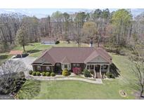 Stunning brick home features a sprawling lawn, covered parking, and a detached garage at 7395 Old Rico Rd., Chattahoochee Hills, GA 30268