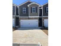 Attractive townhome featuring a two-car garage and brick and siding exterior in a desirable neighborhood at 11523 Kimberly Way # 6, Hampton, GA 30228