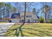 Traditional two-story home featuring a manicured lawn, two-car garage, and charming facade with black shutters at 339 Kensington Dr, Peachtree City, GA 30269