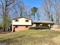 Traditional-style home featuring brick and vinyl siding, a carport, and a well-maintained lawn at 4617 Palm Dr, Douglasville, GA 30135