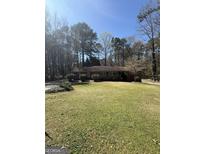 Charming ranch-style home with a large front lawn and mature trees at 9491 Hidden Branch Dr, Jonesboro, GA 30236