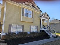 Charming two-story home with yellow siding, complemented by brown shutters and landscaped yard at 946 Creek Run Pl, Temple, GA 30179