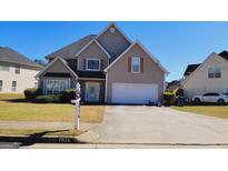 Charming two-story home with a well-manicured lawn and attached two-car garage, perfect for Gathering living at 7926 Palomino Pass, Riverdale, GA 30274